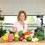 Business Branding - Woman sitting in Kitchen with fresh fruit and vegetables and powerblender  - ready to cook healthily